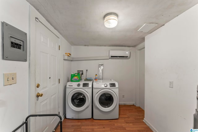 laundry area with separate washer and dryer, hardwood / wood-style flooring, and a wall mounted air conditioner