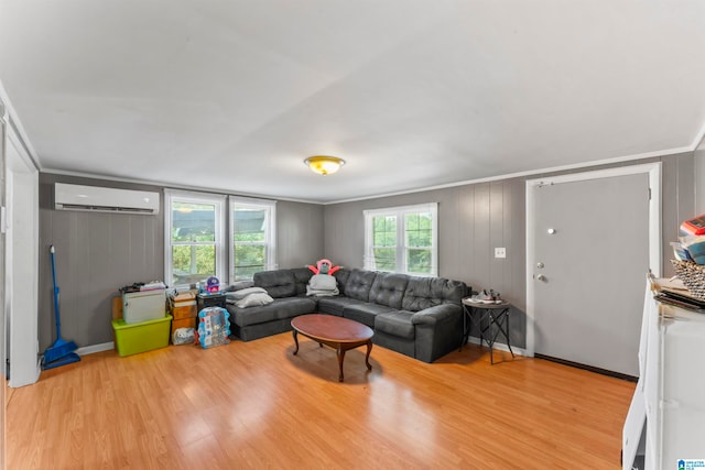 living room with light wood-type flooring, crown molding, and an AC wall unit