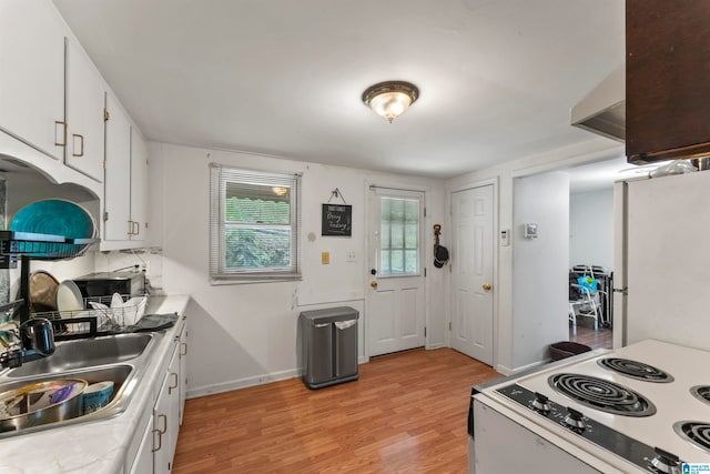 kitchen featuring sink, range, light wood-type flooring, white cabinets, and white refrigerator