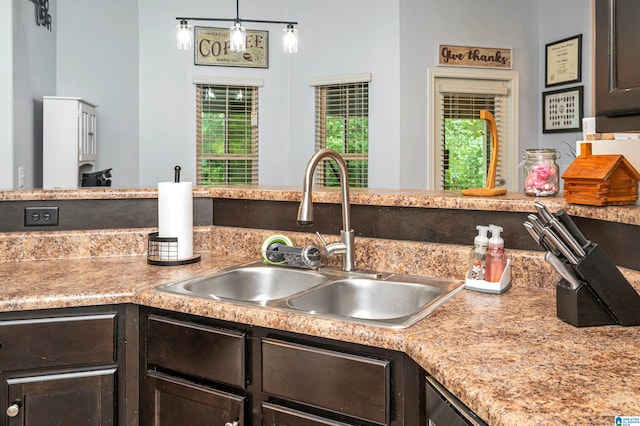 kitchen featuring hanging light fixtures, sink, and dark brown cabinets