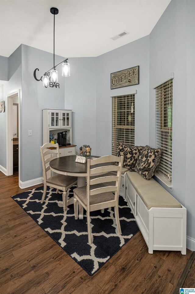 kitchen featuring dark brown cabinets, stainless steel appliances, dark hardwood / wood-style flooring, and stone countertops