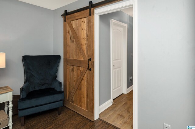 bedroom featuring a tray ceiling, ceiling fan, a barn door, and dark hardwood / wood-style floors