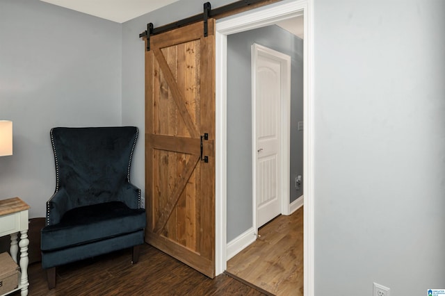 sitting room featuring a barn door and hardwood / wood-style floors