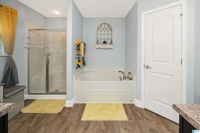 bathroom featuring vanity, wood-type flooring, and shower with separate bathtub