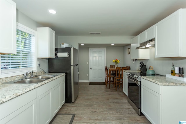 kitchen featuring white cabinetry, appliances with stainless steel finishes, sink, and light hardwood / wood-style flooring