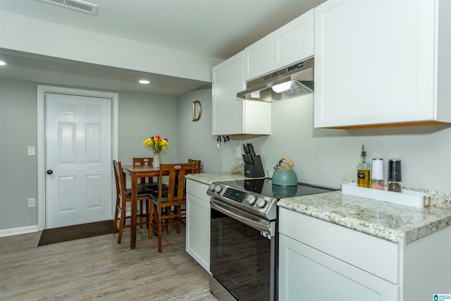 kitchen with white cabinetry, light hardwood / wood-style floors, and stainless steel electric range oven