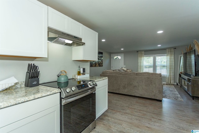 kitchen featuring light hardwood / wood-style flooring, white cabinets, and electric range