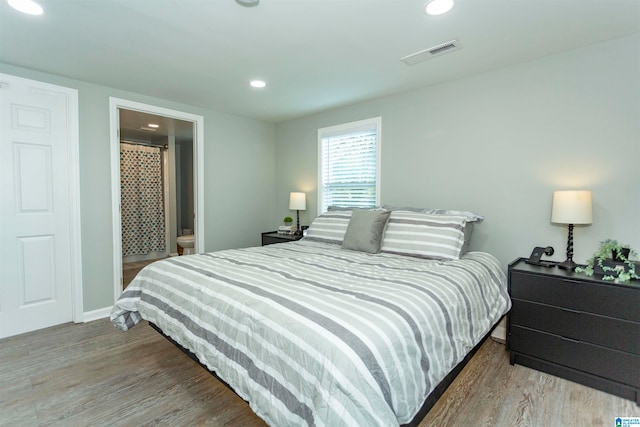 bedroom with light hardwood / wood-style flooring and connected bathroom