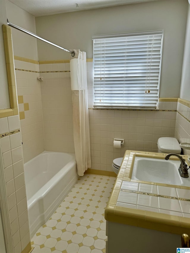 full bath featuring shower / tub combo, vanity, toilet, and tile walls