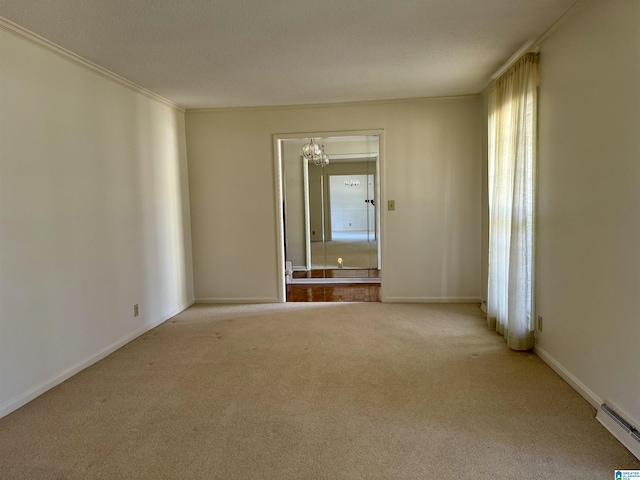 spare room featuring baseboards, light colored carpet, crown molding, and baseboard heating