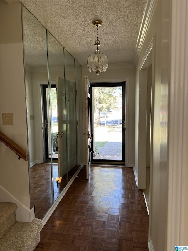 doorway to outside featuring ornamental molding, a notable chandelier, plenty of natural light, and stairs