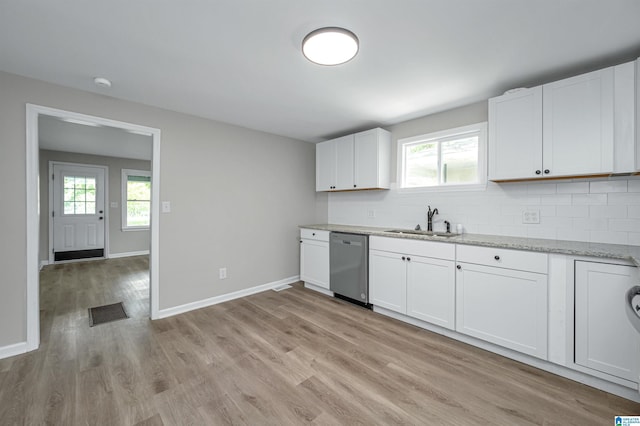 kitchen with a sink, baseboards, stainless steel dishwasher, light wood-type flooring, and tasteful backsplash