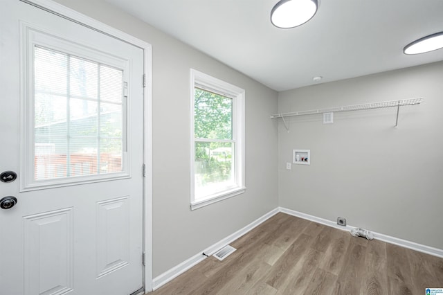 laundry room with hookup for a washing machine, laundry area, visible vents, baseboards, and light wood-type flooring