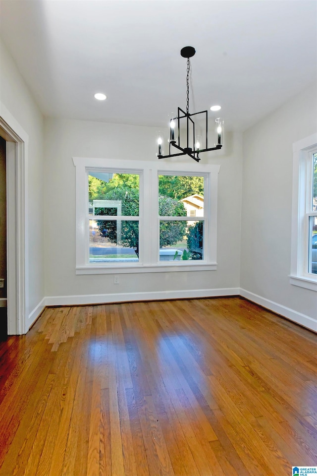 unfurnished dining area featuring light hardwood / wood-style flooring and a chandelier