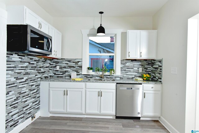 kitchen featuring stainless steel appliances, light hardwood / wood-style flooring, decorative backsplash, sink, and white cabinets