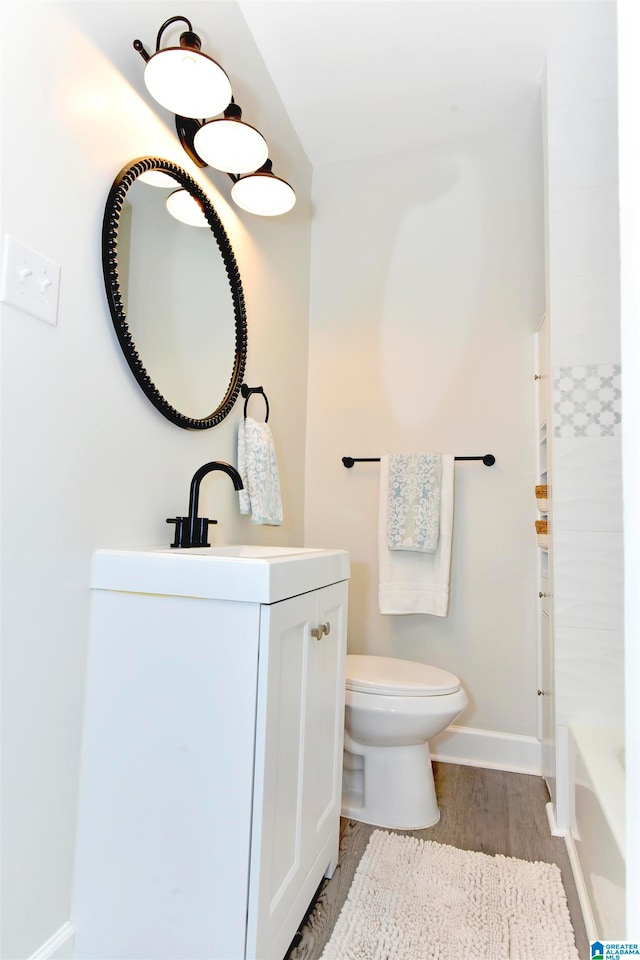 bathroom with wood-type flooring, toilet, and vanity