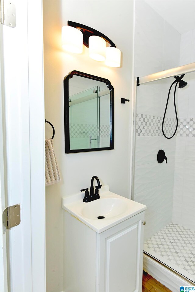 bathroom featuring a shower with door, vanity, and hardwood / wood-style floors