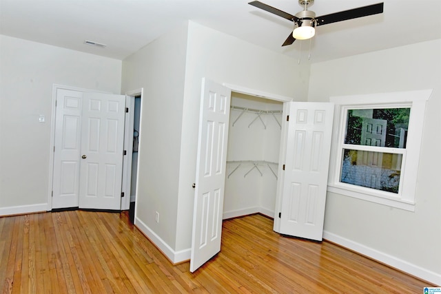 unfurnished bedroom featuring ceiling fan, a closet, and light hardwood / wood-style flooring