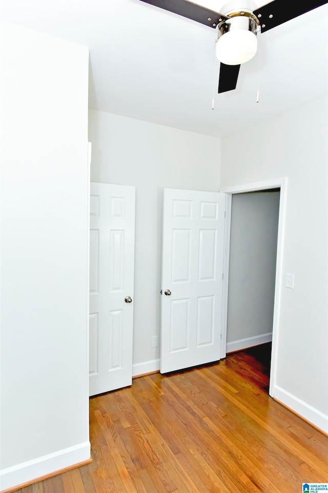 unfurnished bedroom with light hardwood / wood-style flooring, ceiling fan, and a closet