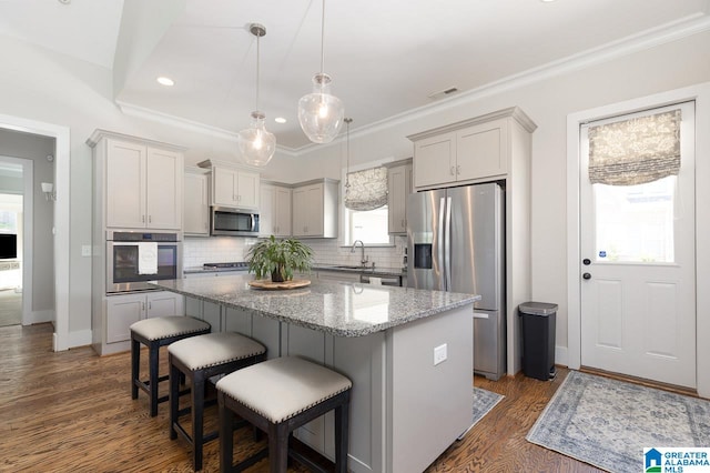 kitchen featuring backsplash, appliances with stainless steel finishes, dark hardwood / wood-style floors, and a kitchen island