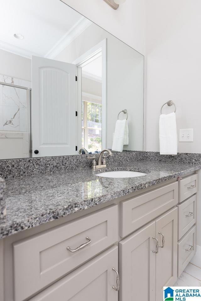 bathroom with tile patterned floors, a shower with shower door, vanity, and crown molding