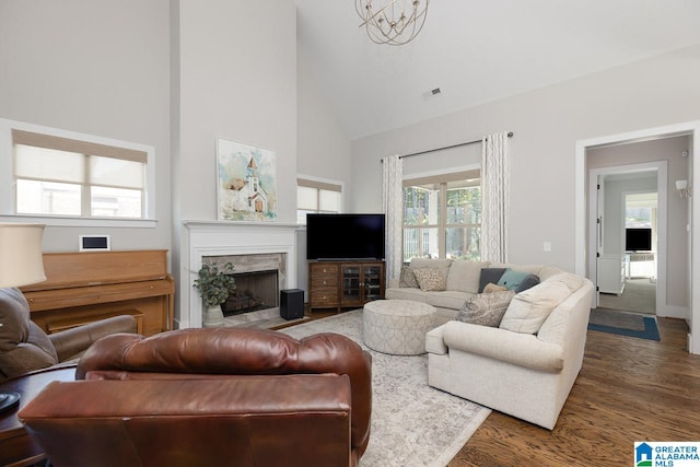 living room featuring high vaulted ceiling, a wealth of natural light, dark wood-type flooring, and a fireplace