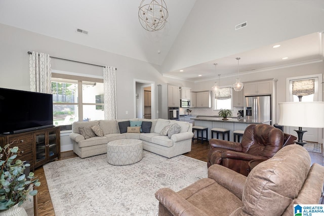 living room featuring an inviting chandelier, dark hardwood / wood-style floors, ornamental molding, and high vaulted ceiling