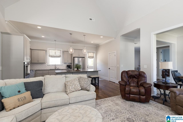 living room featuring ornamental molding, wood-type flooring, and sink