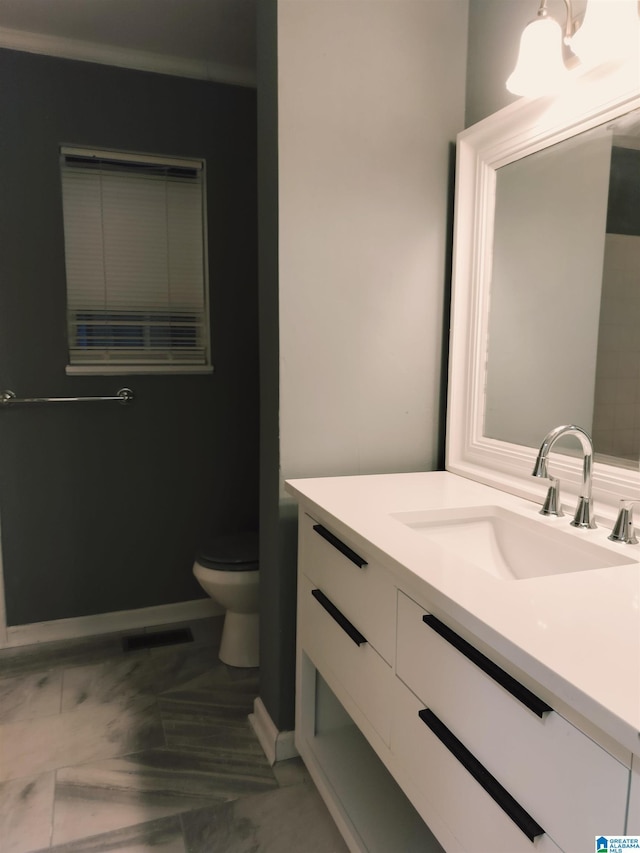 bathroom with visible vents, baseboards, vanity, and toilet