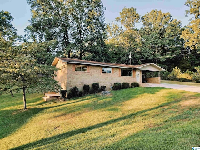 ranch-style home featuring an attached carport, concrete driveway, and a front lawn