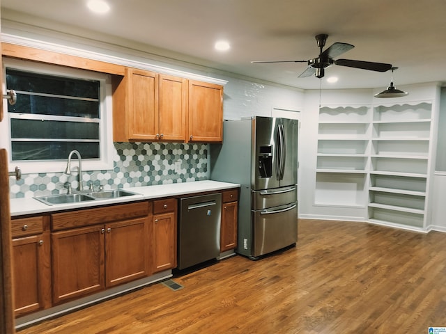 kitchen featuring brown cabinets, appliances with stainless steel finishes, light countertops, and a sink