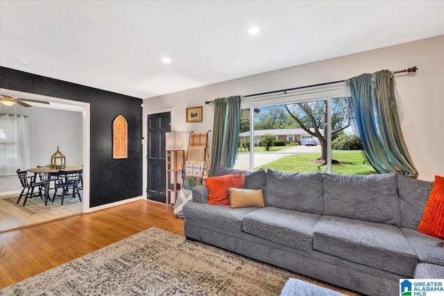 living room with light hardwood / wood-style flooring and ceiling fan