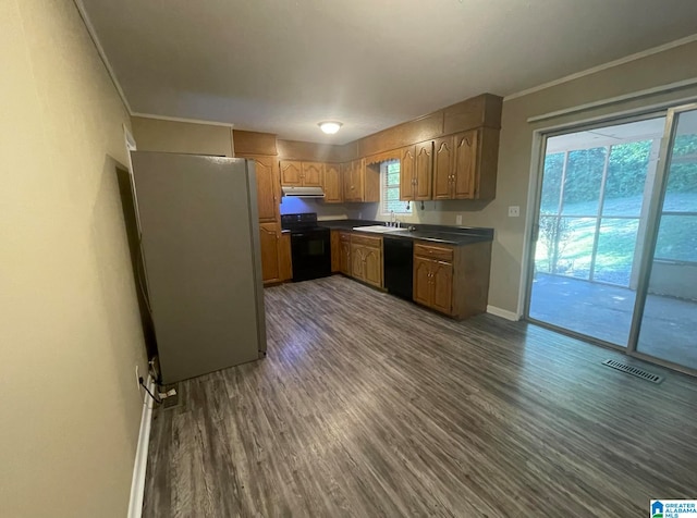 kitchen with black dishwasher, plenty of natural light, range, and dark hardwood / wood-style floors