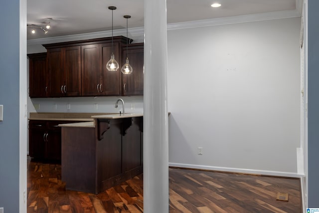 kitchen with track lighting, ornamental molding, dark hardwood / wood-style flooring, hanging light fixtures, and a breakfast bar