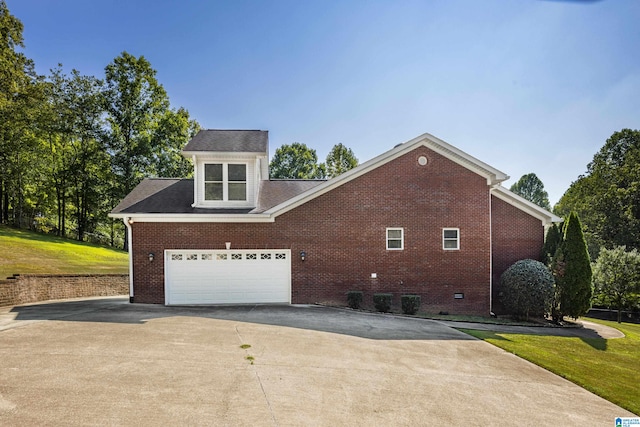 view of side of property featuring a lawn and a garage