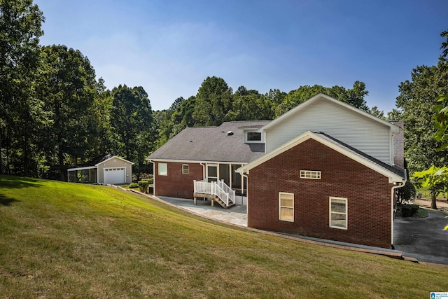 back of house with a garage, an outbuilding, and a lawn