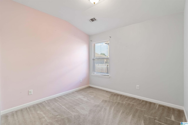 carpeted empty room with lofted ceiling