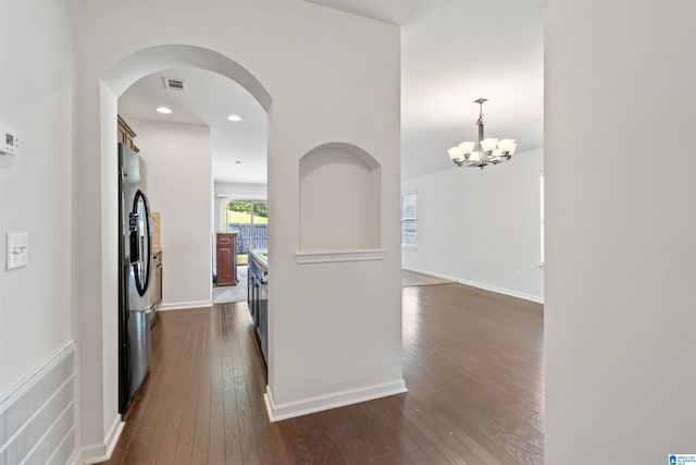 kitchen with stainless steel fridge with ice dispenser, dark hardwood / wood-style flooring, decorative light fixtures, and a notable chandelier