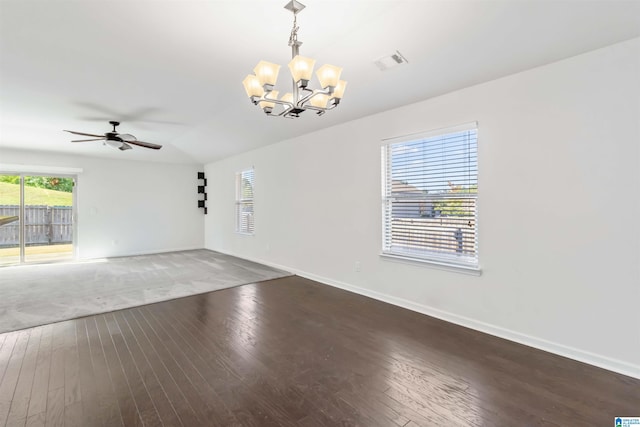 spare room with ceiling fan with notable chandelier and dark wood-type flooring