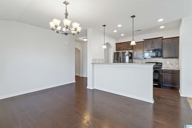 kitchen featuring black appliances, dark hardwood / wood-style floors, decorative light fixtures, and decorative backsplash