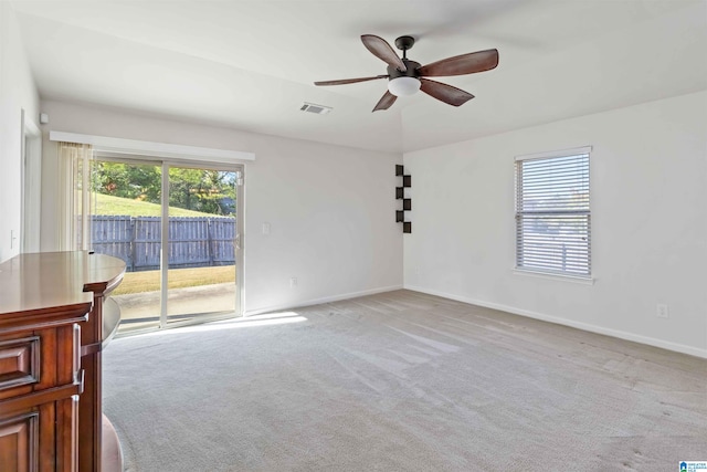 carpeted spare room featuring ceiling fan