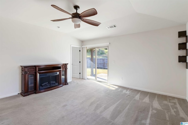 unfurnished living room featuring lofted ceiling, ceiling fan, and light carpet