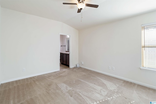 unfurnished room with light colored carpet, vaulted ceiling, and ceiling fan