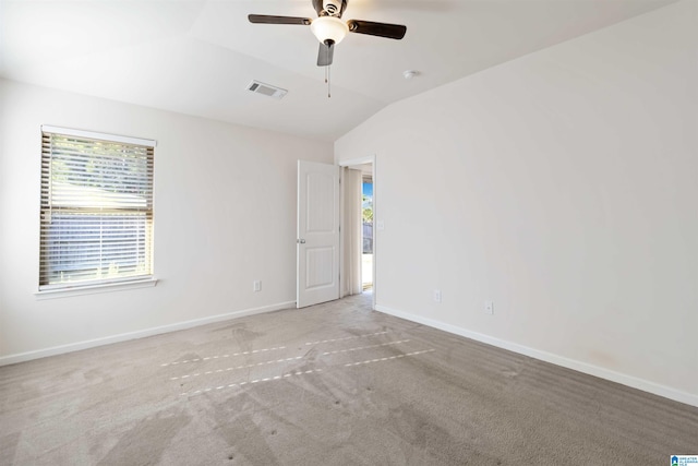 spare room with lofted ceiling, ceiling fan, a wealth of natural light, and light colored carpet