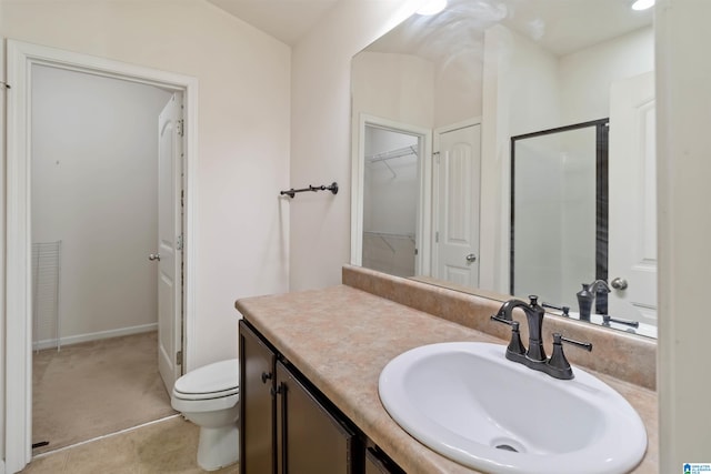 bathroom with a shower with door, vanity, toilet, and tile patterned flooring