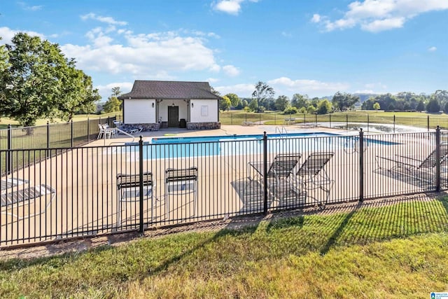 view of pool with a patio area and a lawn