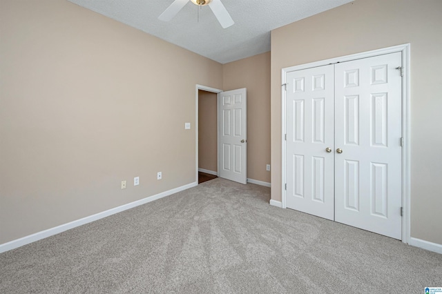 unfurnished bedroom featuring a textured ceiling, light colored carpet, ceiling fan, and a closet