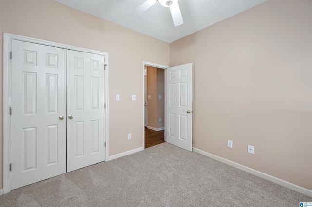 unfurnished bedroom with ceiling fan, a closet, and carpet floors