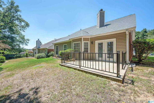 back of house featuring a yard and french doors