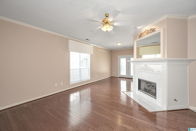 unfurnished living room featuring a tile fireplace, hardwood / wood-style flooring, ceiling fan, ornamental molding, and a textured ceiling